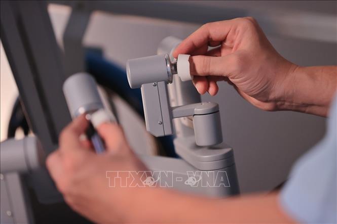 Với sự hỗ trợ của hệ thống robot hiện đại, các bác sỹ phẫu tích chính xác từng lớp mô trong không gian hẹp, thực hiện cắt nối trong điều kiện hình ảnh rõ nét và thao tác linh hoạt chính xác hơn. (Ảnh: Minh Quyết/TTXVN)